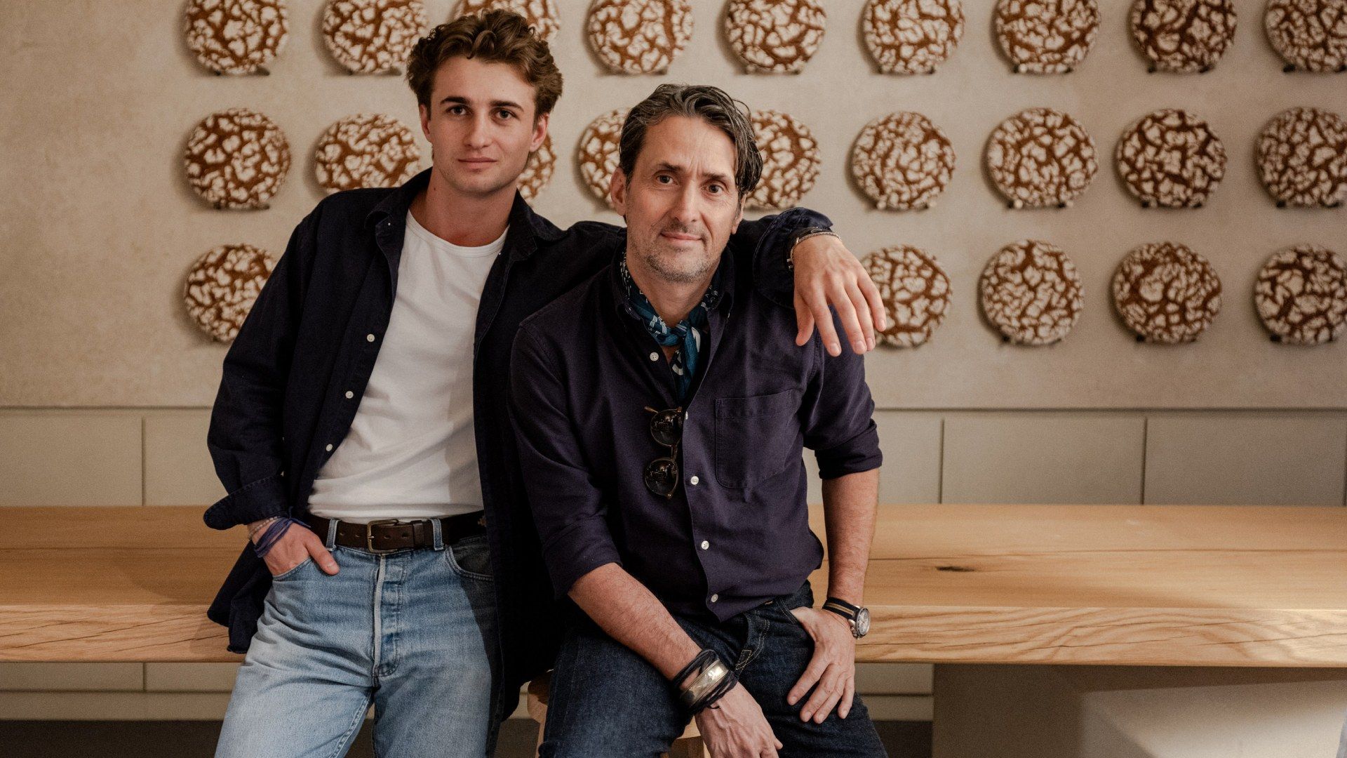 Lifestyle photography for RYE by Martin Auer featuring the founders seated before a wall of rye loaves by TRUFFL branding agency